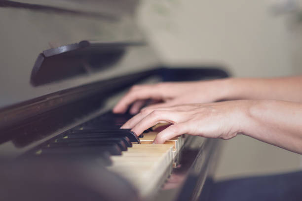 istock Close up of two hands playing piano, shallow focus. 1141975953