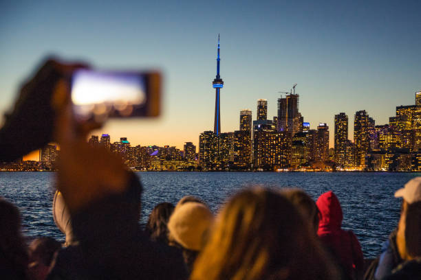 люди фотографируют красивый горизонт торонто ночью - toronto skyline cn tower night стоковые фото и изображения