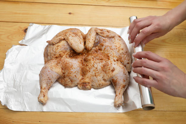 Marinated chicken on the foil. stock photo