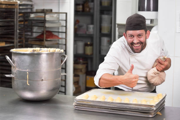 istock Pastry Chef with confectionary bag squeezing cream at pastry shop. 1141978541