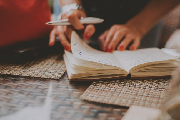 istock business woman writing something in a notebook in a cafe 1141978624