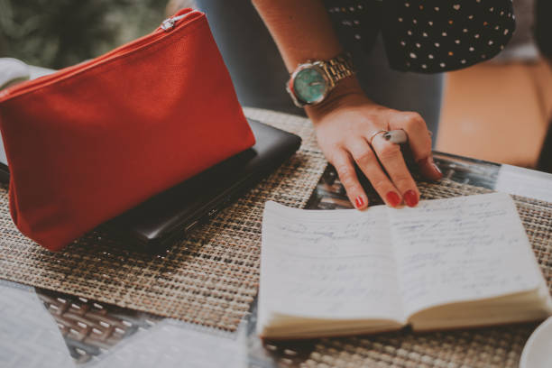 istock business woman writing something in a notebook in a cafe 1141978649