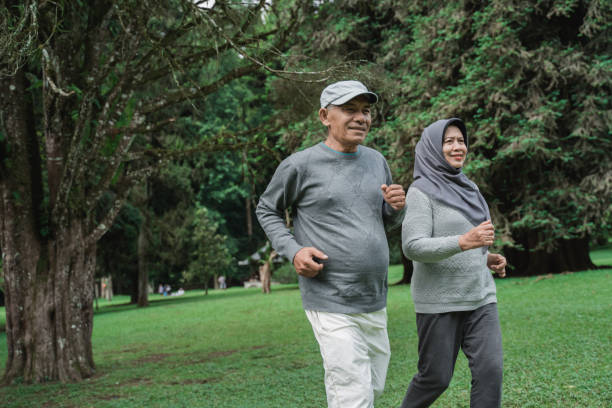 istock couple doing exercising by running in the garden 1141980558