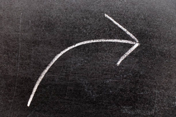 istock White chalk hand drawing in moving right arrow shape on black board background 1141983806