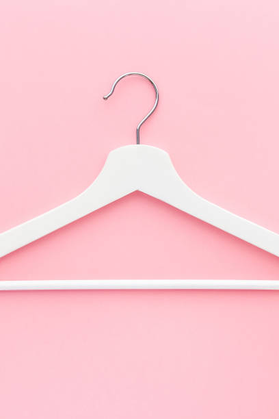 istock White hangers on pastel pink background 1141984029