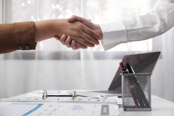 istock two young female professional shaking hand business concept. 1141984202