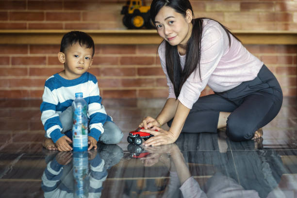 asiatique seule maman avec fils jouent avec le jouet de voiture ensemble quand vivant dans la maison moderne pour l’auto-apprentissage ou l’école à la maison, la famille et le concept de mère unique, focus sélectif - brown boy photos et images de collection