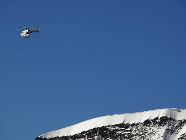 istock A helicopter flies over the mountain 1141984432
