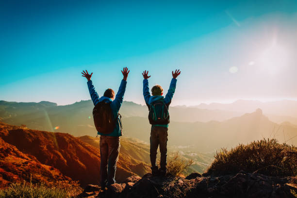 istock Happy father and son hiking at sunset mountains 1141986034