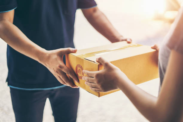 istock Delivery man delivering holding parcel box to customer 1141986054