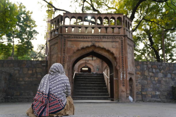 Delhi, India - 16 March 2019: A woman sit outside a Mosque while female cannot enter.