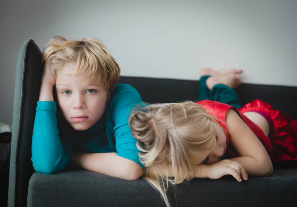 brother and sister bored staying home, kids sadness and stress stock photo