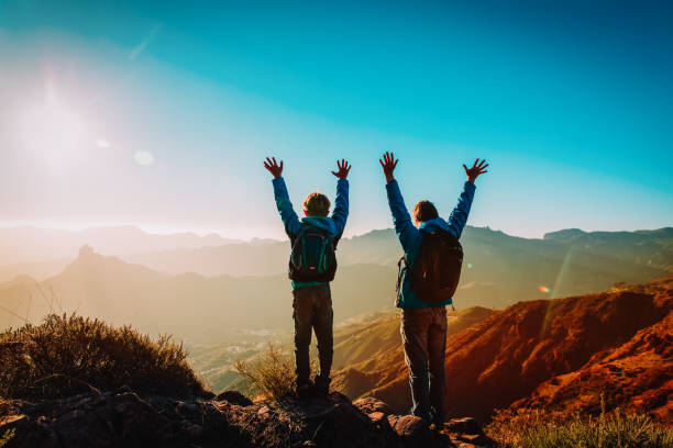 istock Happy father and son hiking at sunset mountains 1141987400