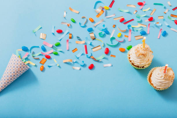 istock birthday hat with confetti and cupcake on blue paper background 1141987645