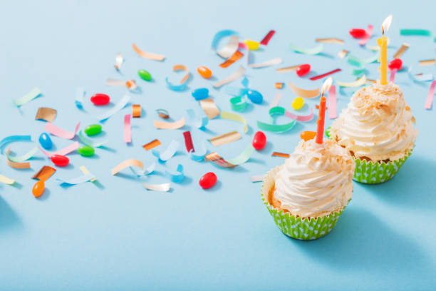 istock birthday hat with confetti and cupcake on blue paper background 1141987648