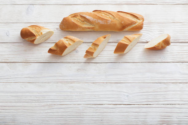 istock baguette on white wooden background 1141987698
