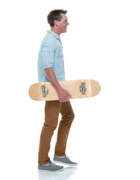 istock Casual well dressed man walking with a skateboard 1141989419