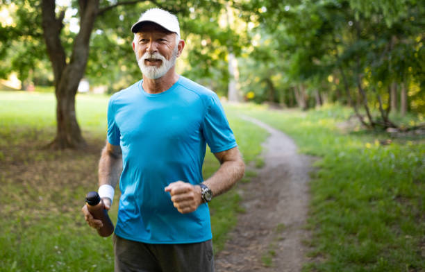공원에서 조깅 하는 멋진 웃음을 가진 매력적인 은퇴 한 남자 - men gray hair vitality healthy lifestyle 뉴스 사진 이미지
