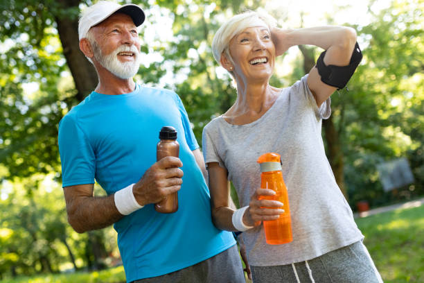 coppia senior che rimane idratata dopo aver fatto jogging - water bottle healthy eating water bottle foto e immagini stock