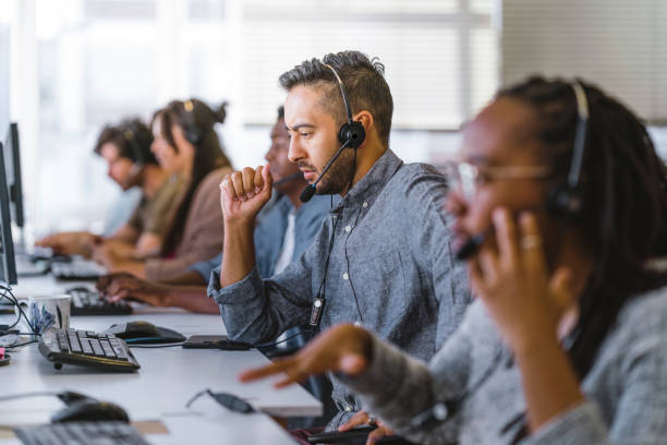 el ejecutivo escucha la consulta del cliente en los auriculares - centro de llamadas fotografías e imágenes de stock