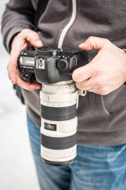 istock Man hand holding camera and take the photo 1141991793