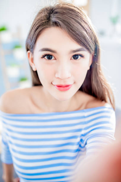 beauty asian woman take a selfie and smile happily at home