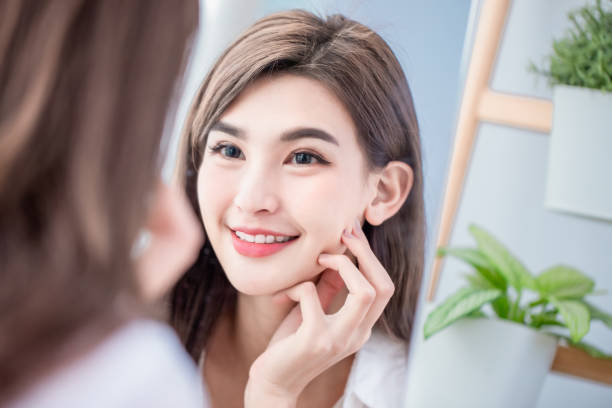 istock woman smile and touch face 1141992649