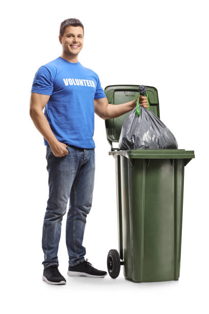 istock Young male volunteer throwing a plastic bag in a bin 1141995766