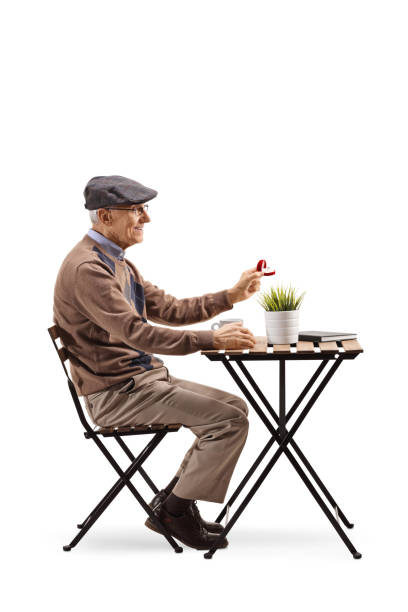 istock Senior man sitting at a cafe and holding a ring in a box 1141997520