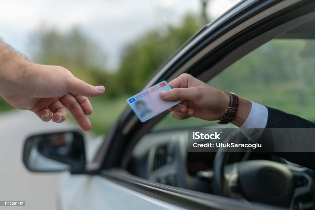 Drivers license Crime: Policeman gives driver a traffic ticket. Driver's License Stock Photo