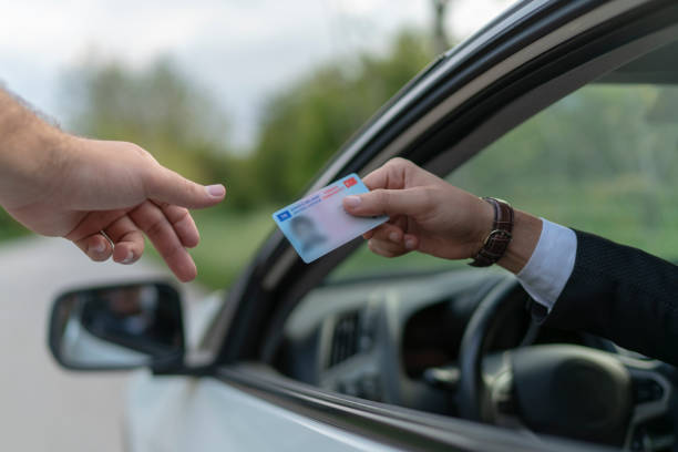 Drivers license Crime: Policeman gives driver a traffic ticket. drivers license photos stock pictures, royalty-free photos & images