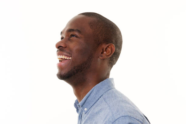 portrait latéral de rire homme afro-américain regardant vers le haut - isolated on black photos photos et images de collection
