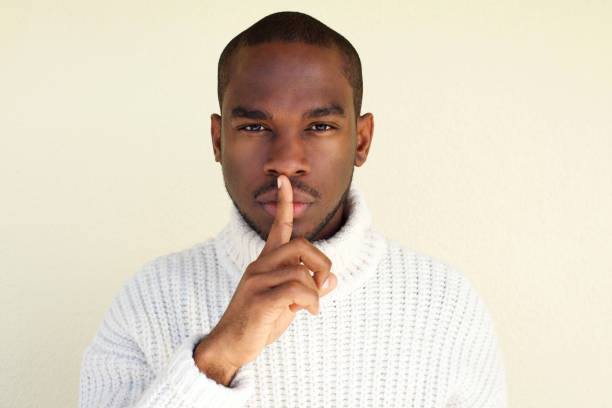 istock Close up handsome young african american man with finger over lips 1142003994