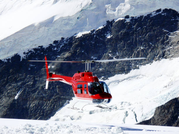 istock Red helicopter on high mountain snow 1142007377