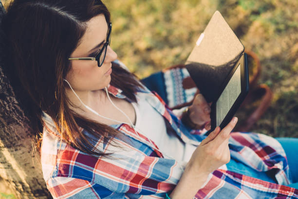 Woman in park reading an e-book