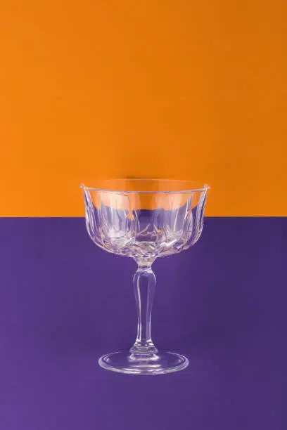 Champagne glass on purple and orange background