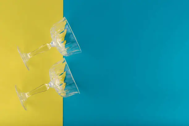 Two champagne glasses on blue and yellow background
