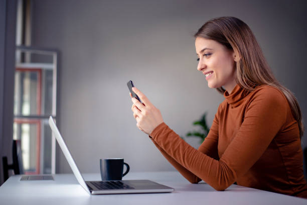 istock Girl holding phone with both hands and happily browsing the internet 1142008888