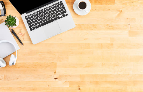 istock Top view of laptop computer on wooden office desk 1142010973