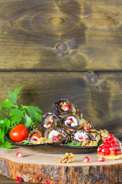 istock Grilled eggplants rolls with nuts, cheese, garlic and herbs and pomegranate seeds, georgian cuisine on wooden background 1142012087