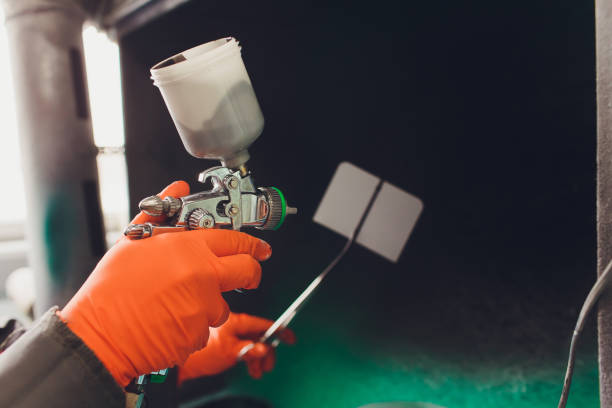 istock Car repair service. Worker painter checking color matching before painting. spraying black liquid onto the fitting plate. 1142014322