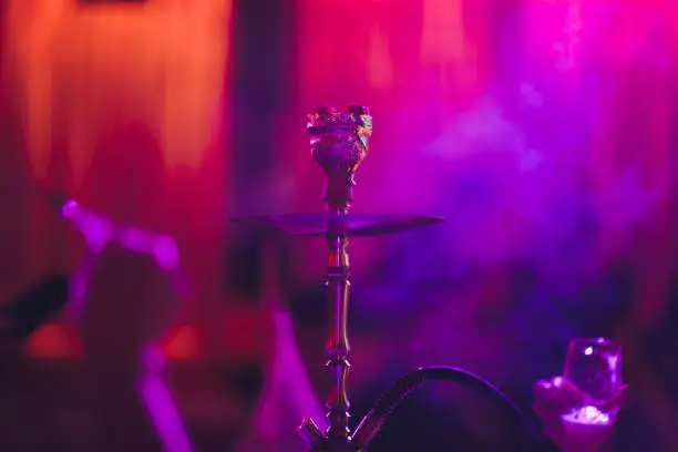 Photo of Hookah on a dark background of a blurry bar with a bokeh.Copy space.