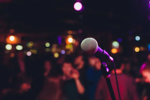 Microphone with blurred colorful bright light in dark night background, soft focus image for business technology communication concepts