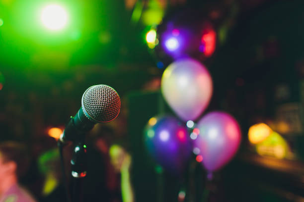istock Microphone with blurred colorful bright light in dark night background, soft focus image for business technology communication concepts. 1142016644