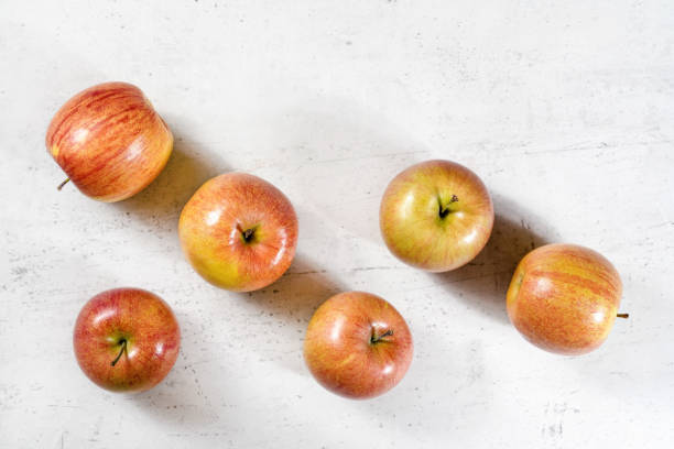 istock Tabletop view, six shiny apples (kiku variety) on white working board 1142022056