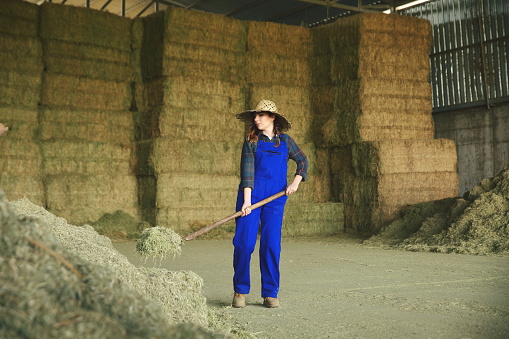 Woman farmer working with hay fork