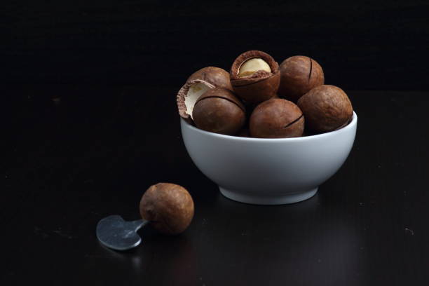 istock a bowl of macadamia nut on black background 1142025667