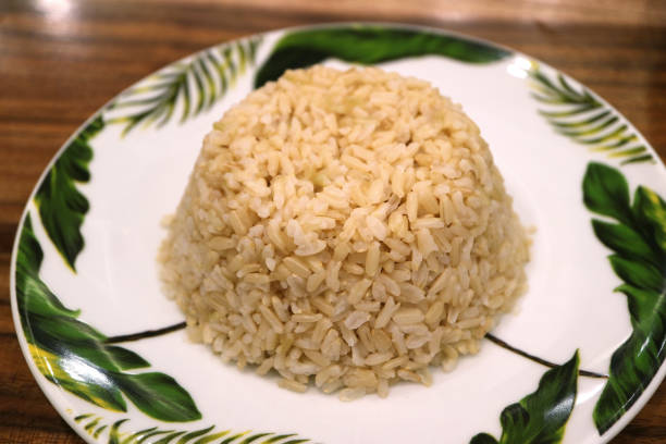 cerrado un plato de arroz integral tailandés al vapor servido sobre mesa de madera - brown rice cooked rice steamed fotografías e imágenes de stock