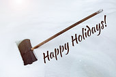 The inscription on the snow Happy Holidays. Big black plastic shovel in snowdrift.  Cleaning of snow after heavy snowfall. Shovel with wooden handle.