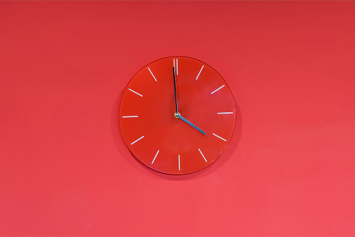 Red round glass clocks hang on a red wall. Shows the current time 4:00 pm